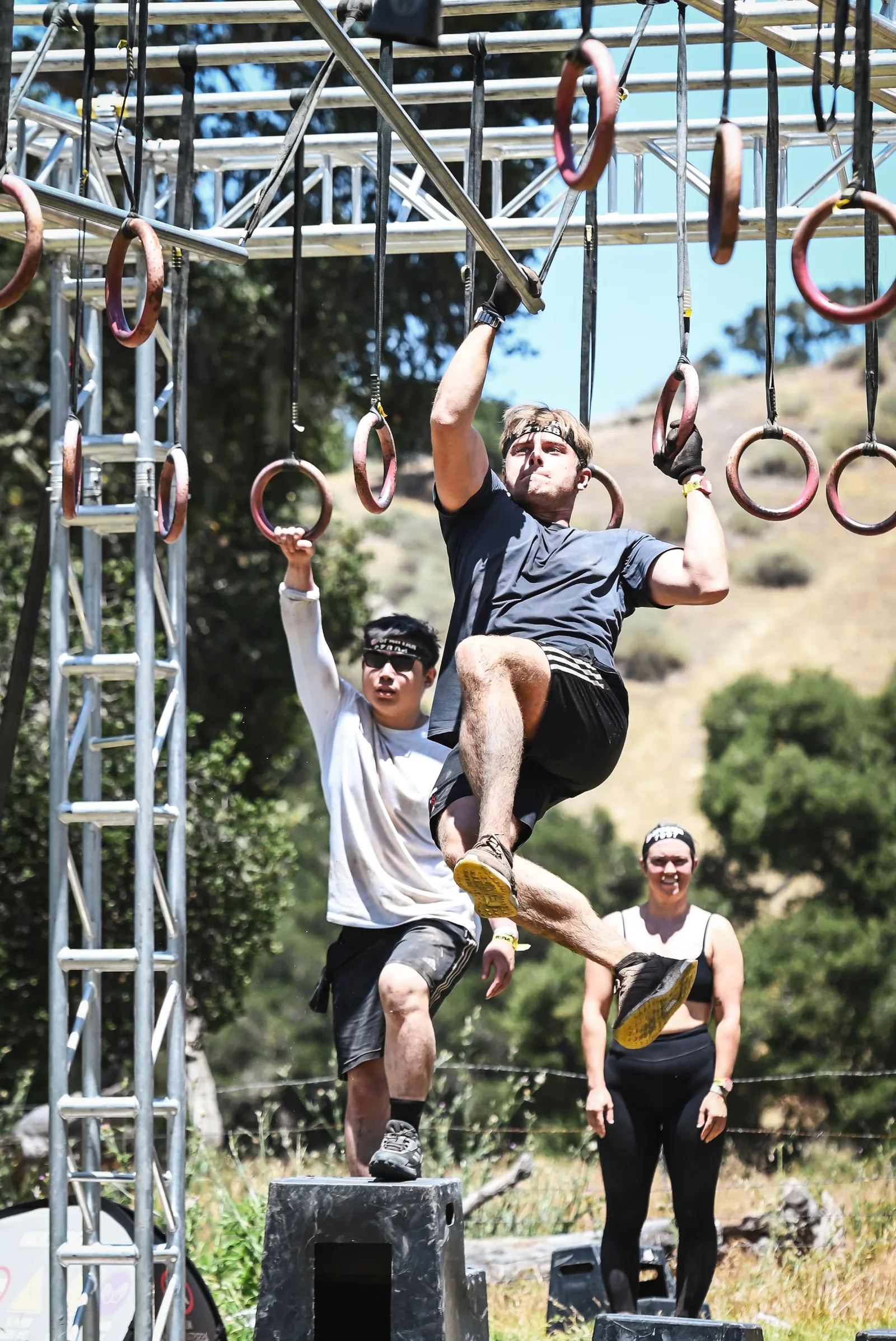 Seb swinging through the rings on a Spartan Race multi-rig.